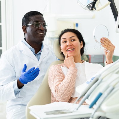 Man and woman sharing healthy smiles after dental implant tooth replacement