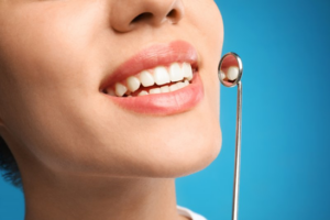 Close up of woman examining her smile with a small mirror