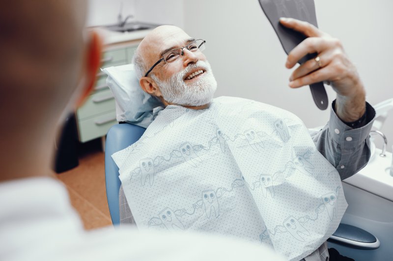 A senior man happy with his new dental implants